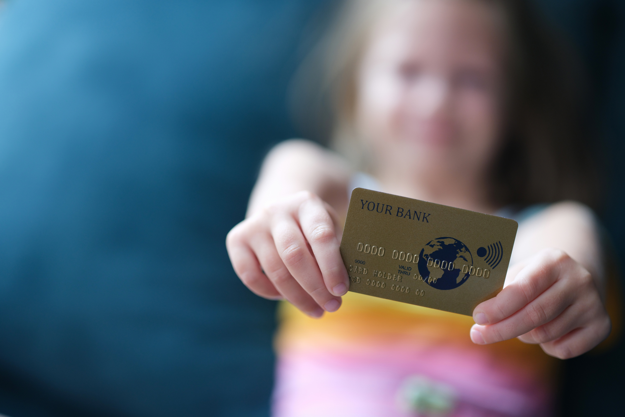 Little girl holding plastic credit card in hands (Getty Images/Ivan-balvan)