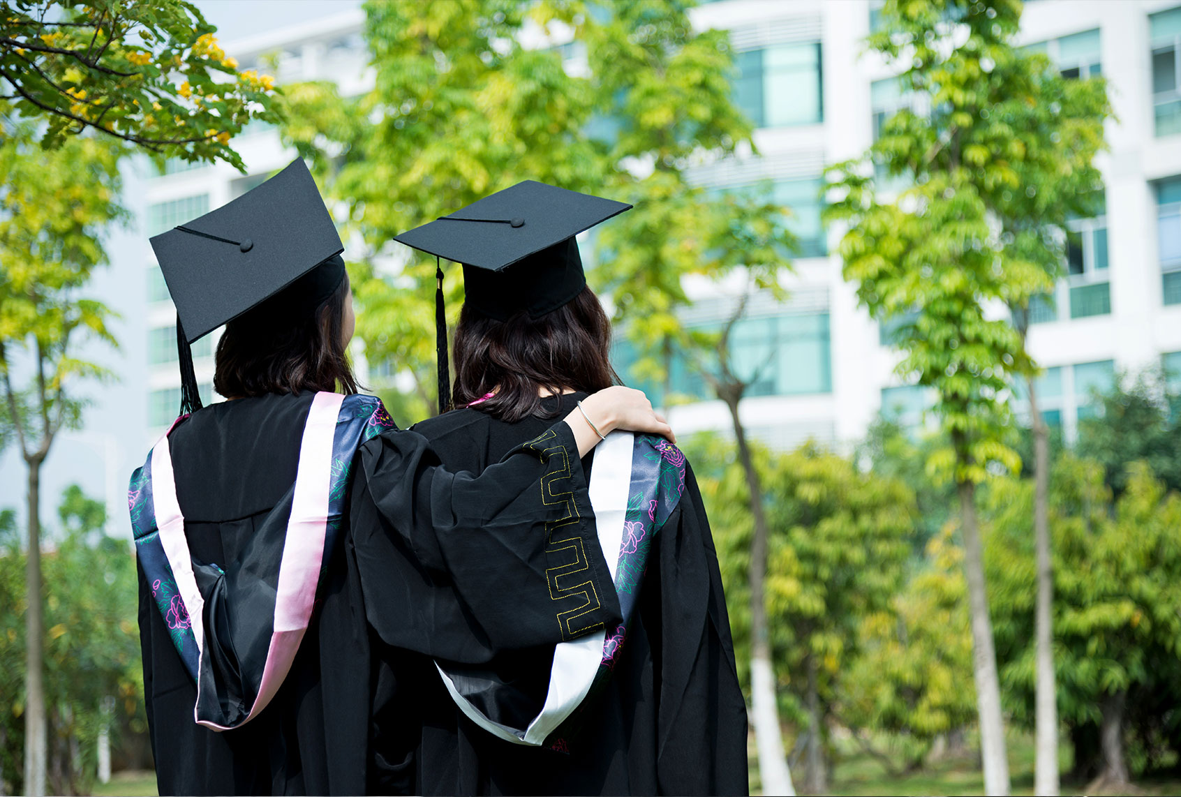 Two college graduates on campus (Getty Images)