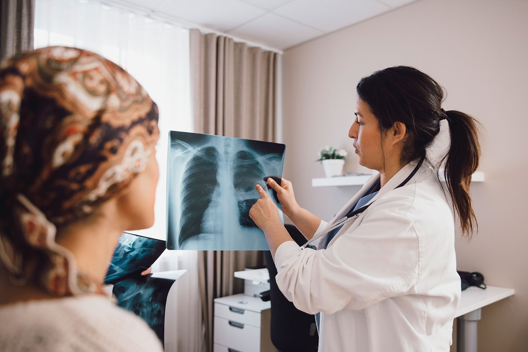 Doctor advising cancer patient while examining x-ray (Getty Images/Maskot)