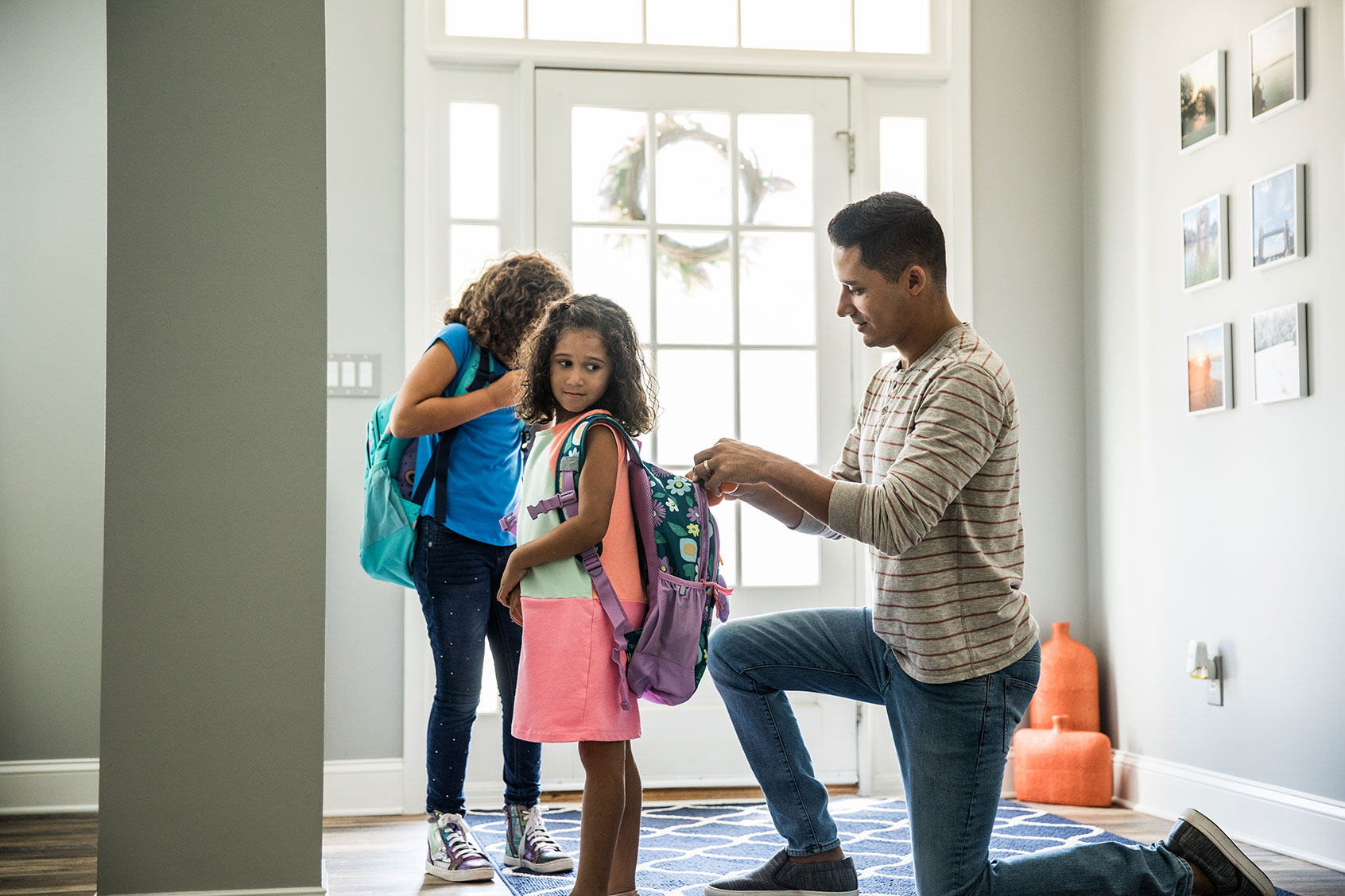 Father packing daughters backpacks for school (Getty Images/MoMo Productions)