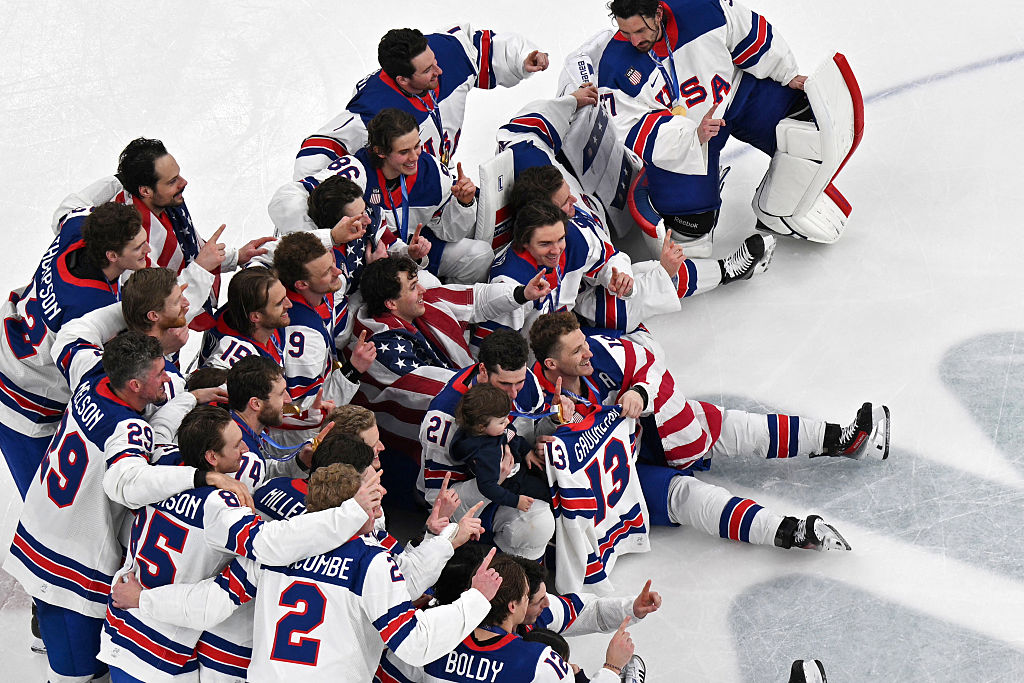 Team USA's hockey players pose for a photo after the men's gold medal ice hockey match between Canada and USA. Included in the group are former teammate Johnny Gaudreau's small children. Gaudreau was killed in 2024 in a cycling accident. (ANTONIN THUILLIER / Getty Images)