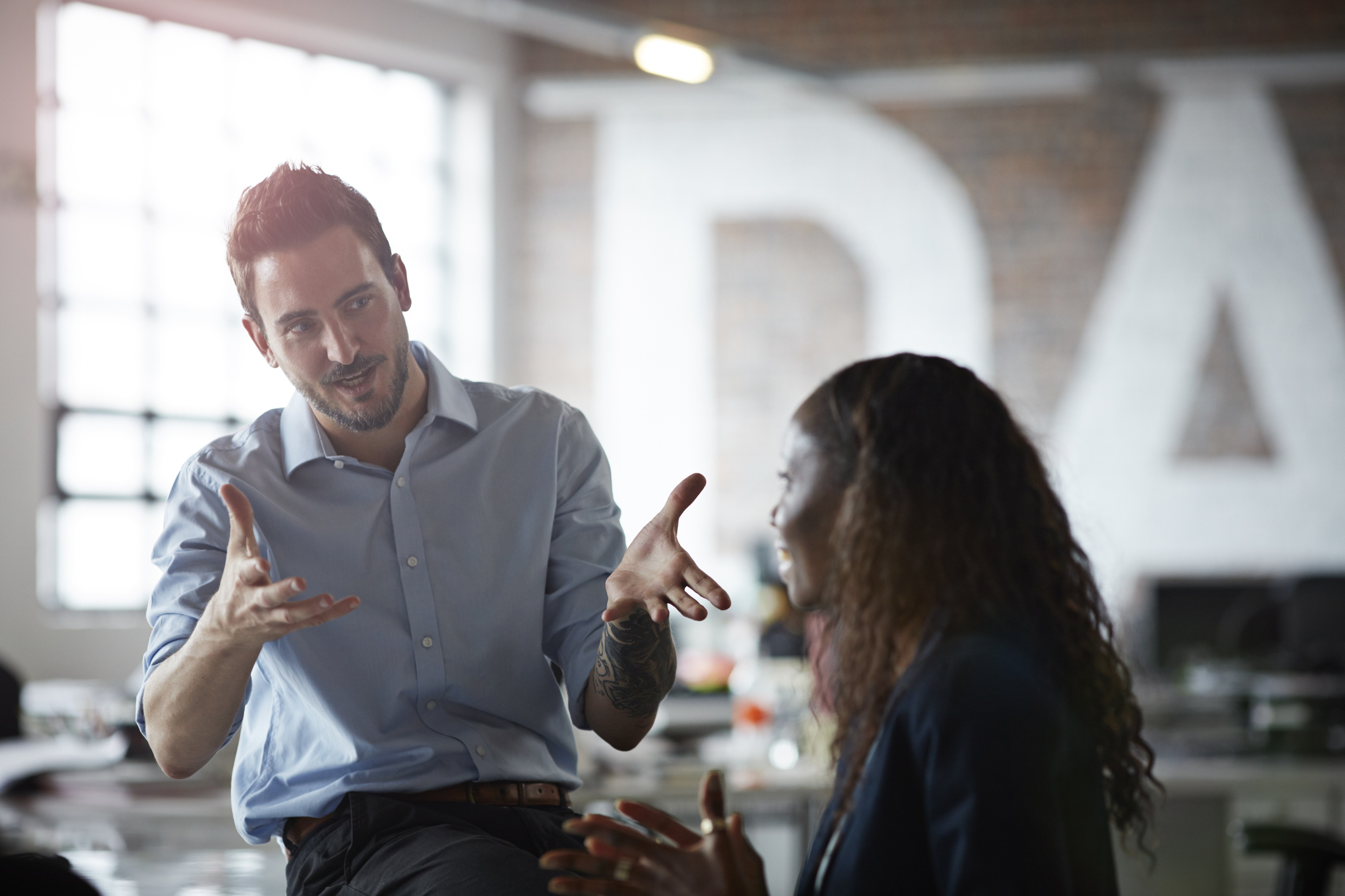 Businessman explaining to coworker (Getty Images/Klaus Vedfelt)